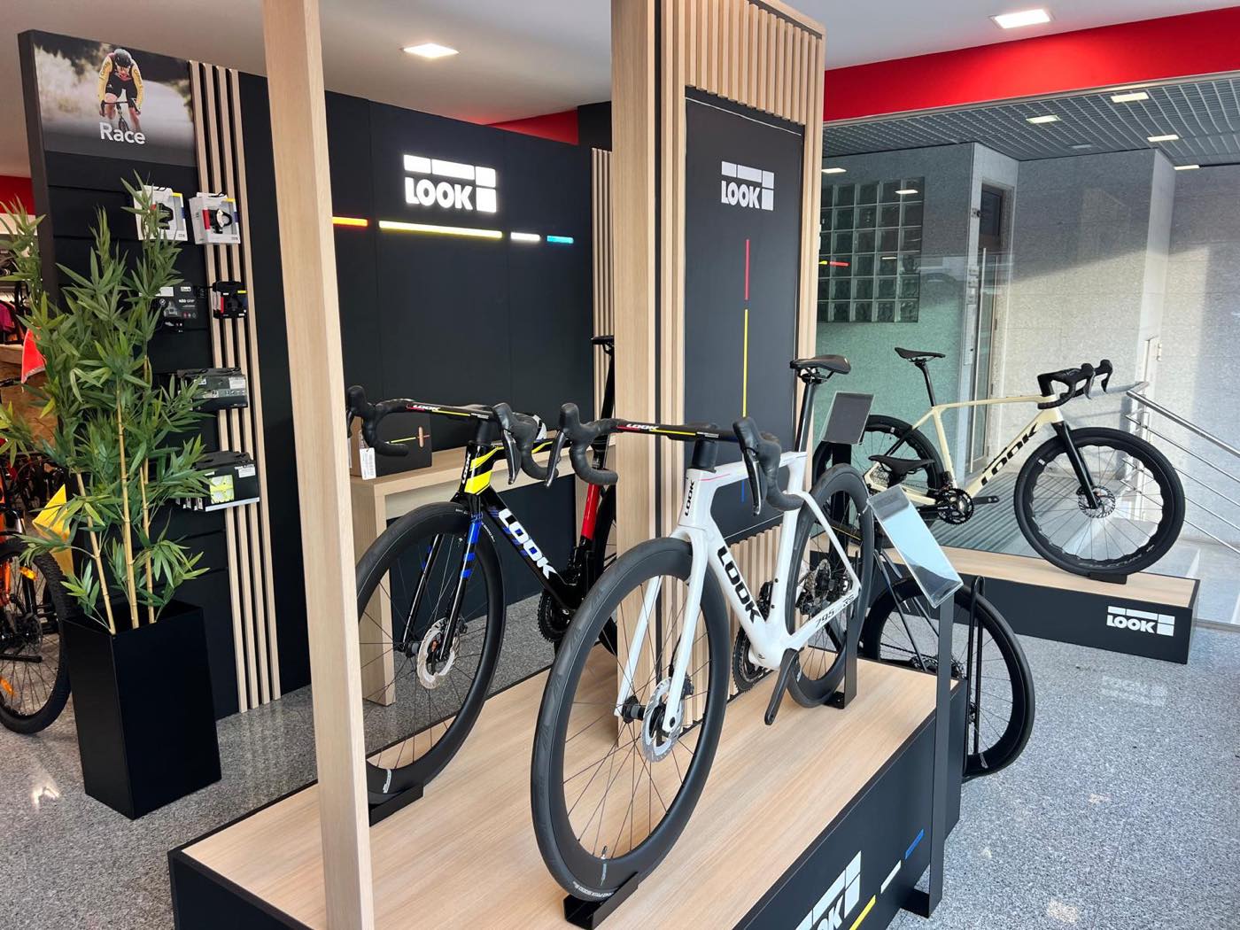 Parede com a marca LOOK na loja de Leiria, com bicicletas de estrada em bases de exposição e uma bicicleta de gravel ao lado